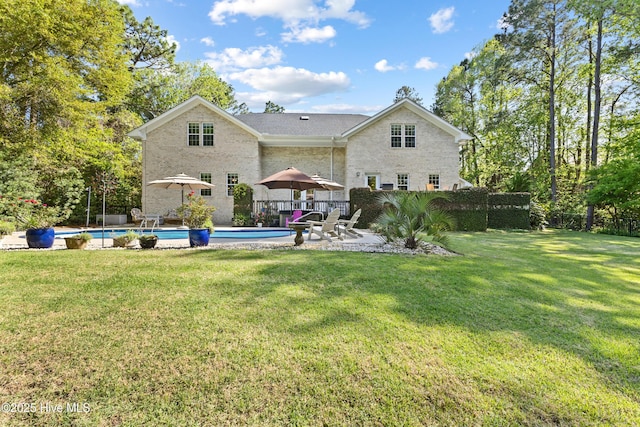 back of house featuring an outdoor pool, a patio, and a yard