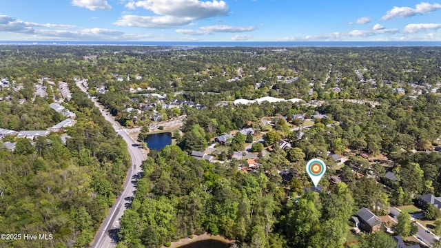 drone / aerial view featuring a forest view and a residential view