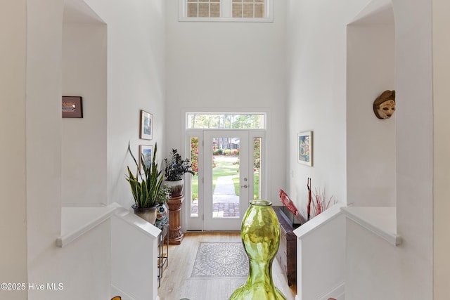 entryway with wood finished floors, a towering ceiling, and visible vents