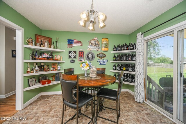 dining room with baseboards, an inviting chandelier, and a textured ceiling