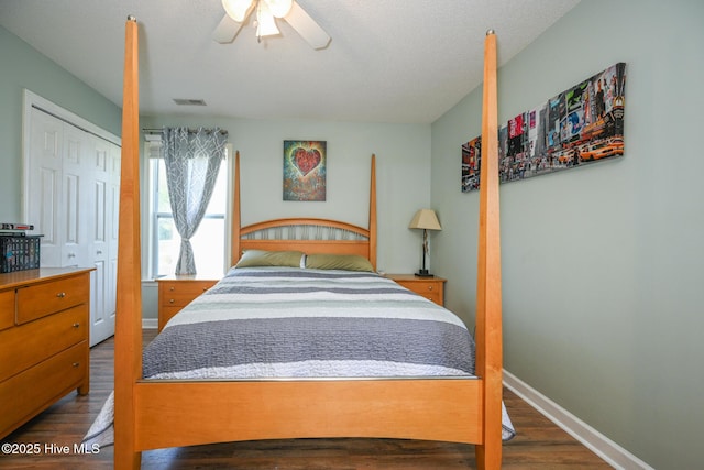 bedroom featuring visible vents, baseboards, a closet, a ceiling fan, and wood finished floors