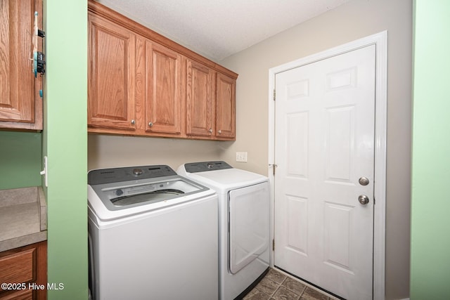 laundry room with cabinet space, washer and dryer, and a textured ceiling