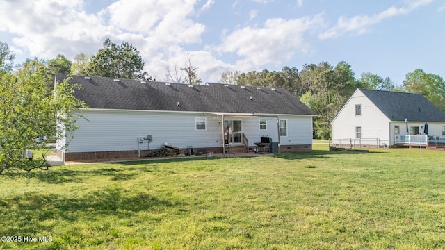 back of property with a yard, entry steps, crawl space, fence, and roof with shingles