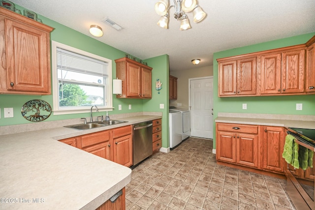 kitchen with visible vents, light countertops, a sink, stainless steel appliances, and washing machine and dryer