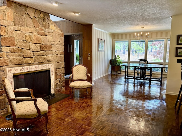 207 Bump A Long Ln, Southern Pines, NC 28387 - living room featuring a notable chandelier, a stone fireplace, baseboards, and a textured ceiling
