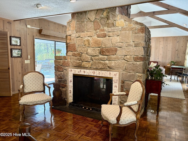 207 Bump A Long Ln, Southern Pines, NC 28387 - living room featuring baseboards, lofted ceiling with beams, a stone fireplace, a textured ceiling, and wood walls