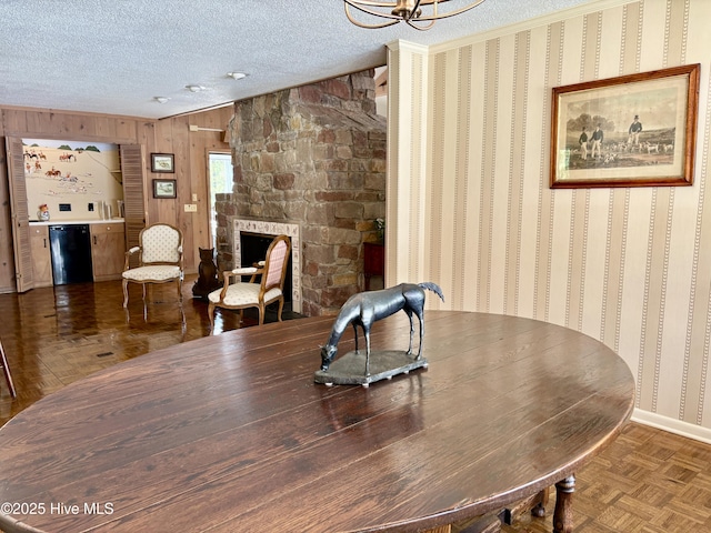 207 Bump A Long Ln, Southern Pines, NC 28387 - dining space featuring baseboards, an inviting chandelier, a stone fireplace, a textured ceiling, and wooden walls