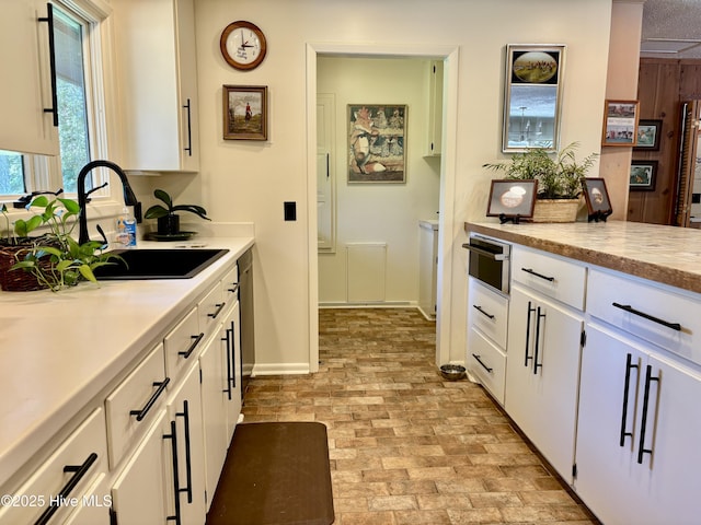 207 Bump A Long Ln, Southern Pines, NC 28387 - kitchen featuring white cabinets, light countertops, a sink, and brick patterned floor
