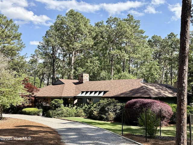 207 Bump A Long Ln, Southern Pines, NC 28387 - view of front facade with board and batten siding, a front yard, a chimney, a shingled roof, and driveway