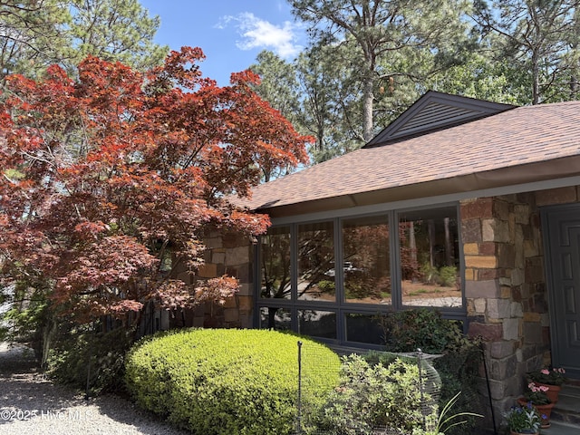207 Bump A Long Ln, Southern Pines, NC 28387 - view of property exterior featuring a shingled roof, stone siding, and a sunroom