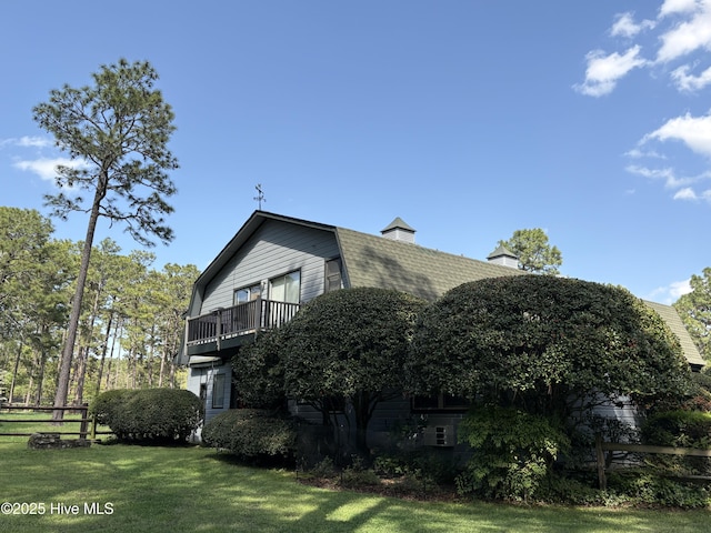 207 Bump A Long Ln, Southern Pines, NC 28387 - view of side of home featuring a gambrel roof, a yard, roof with shingles, a balcony, and a chimney