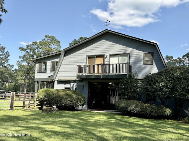 207 Bump A Long Ln, Southern Pines, NC 28387 - view of front of house featuring a front lawn, fence, a gambrel roof, and a balcony