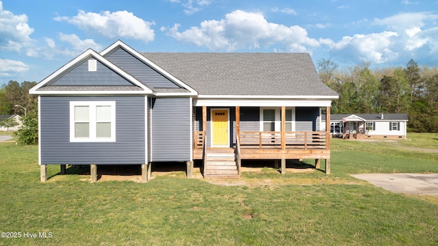 view of front of property with roof with shingles, a front lawn, and covered porch