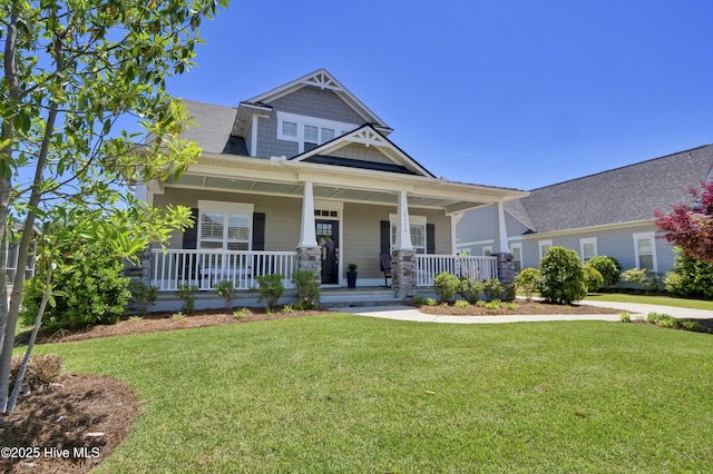 craftsman-style home featuring covered porch and a front lawn