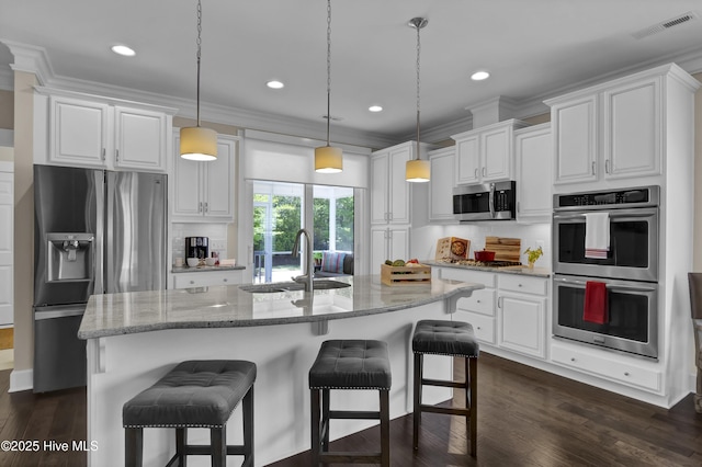 kitchen with visible vents, appliances with stainless steel finishes, light stone countertops, a sink, and white cabinets