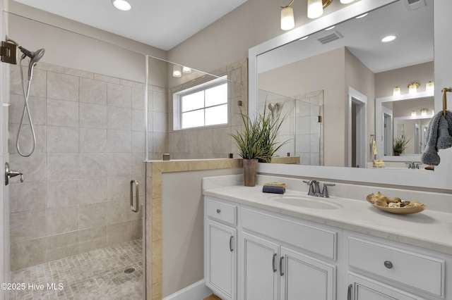 full bath with visible vents, vanity, and a shower stall