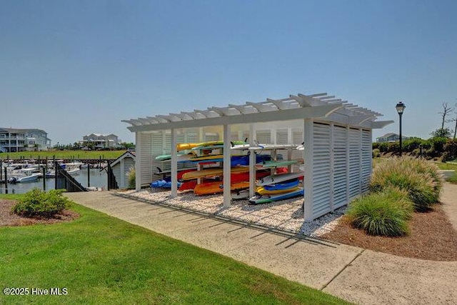 view of outdoor structure with a water view and a pergola