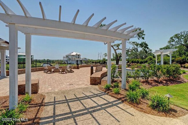 surrounding community featuring a pergola, fence, a patio, and an outdoor fire pit