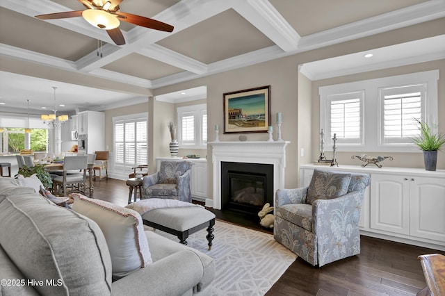 living area with a fireplace with flush hearth, crown molding, beam ceiling, ceiling fan with notable chandelier, and recessed lighting