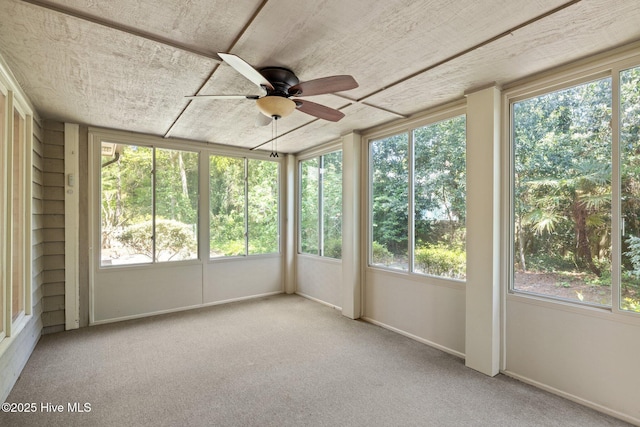 unfurnished sunroom featuring a wealth of natural light and a ceiling fan