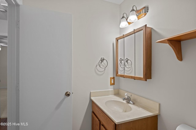 half bathroom featuring vanity and toilet