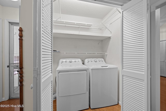 washroom featuring independent washer and dryer, light wood finished floors, and laundry area