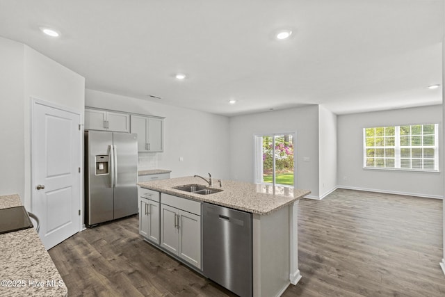 5900 Santo Domingo Ct, New Bern, NC 28560 - kitchen with dark wood-style flooring, light stone countertops, a sink, stainless steel appliances, and an island with sink