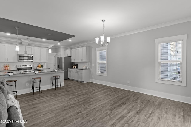 761 Cypress Village Pl, Wilmington, NC 28412 - kitchen with tasteful backsplash, open floor plan, a kitchen bar, appliances with stainless steel finishes, and ornamental molding