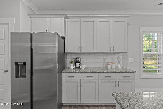 761 Cypress Village Pl, Wilmington, NC 28412 - kitchen featuring white cabinets, visible vents, backsplash, light stone counters, and stainless steel refrigerator with ice dispenser
