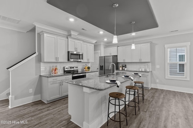 761 Cypress Village Pl, Wilmington, NC 28412 - kitchen with stainless steel appliances, visible vents, ornamental molding, a sink, and dark wood-type flooring