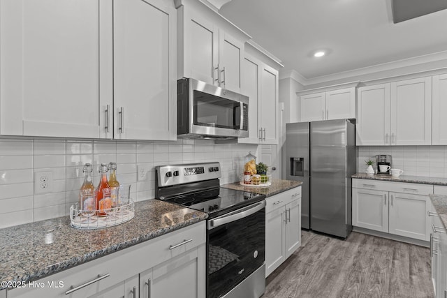 761 Cypress Village Pl, Wilmington, NC 28412 - kitchen with ornamental molding, dark stone counters, tasteful backsplash, appliances with stainless steel finishes, and white cabinetry