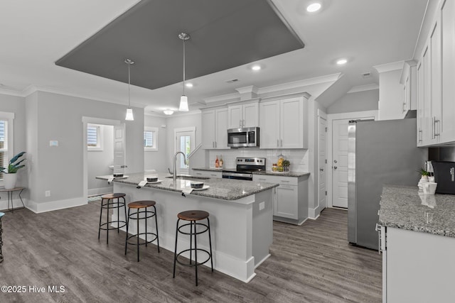 761 Cypress Village Pl, Wilmington, NC 28412 - kitchen featuring stainless steel appliances, a sink, white cabinetry, crown molding, and a breakfast bar