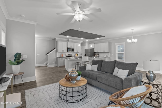 761 Cypress Village Pl, Wilmington, NC 28412 - living room with ceiling fan with notable chandelier, wood finished floors, stairs, and ornamental molding