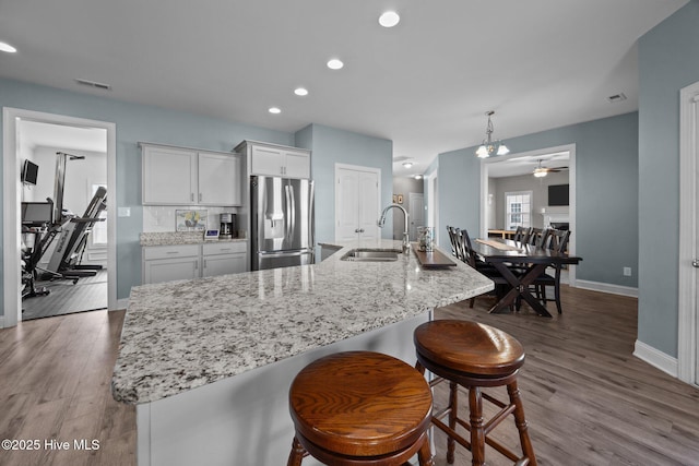506 White Shoal Way, Sneads Ferry, NC 28460 - kitchen with stainless steel fridge, a sink, a ceiling fan, baseboards, and white cabinetry
