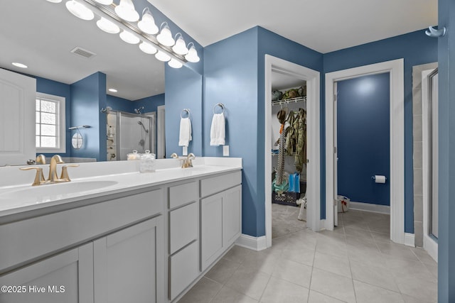 506 White Shoal Way, Sneads Ferry, NC 28460 - bathroom featuring a walk in closet, a sink, double vanity, a shower stall, and visible vents