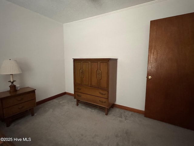 bedroom featuring ornamental molding, baseboards, and light colored carpet
