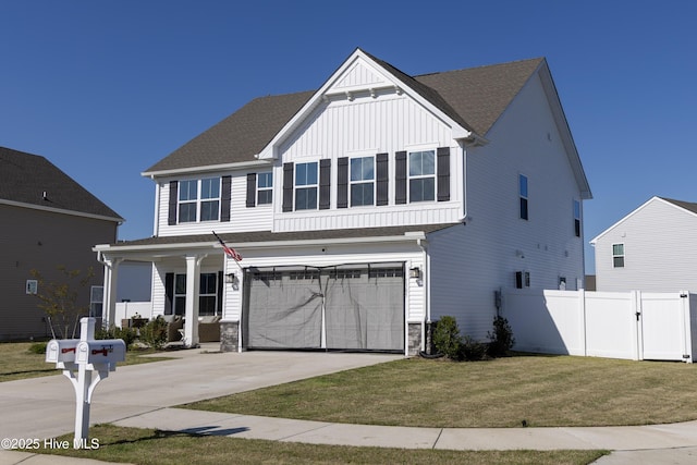 view of front of property featuring driveway, board and batten siding, a front yard, a garage, and fence