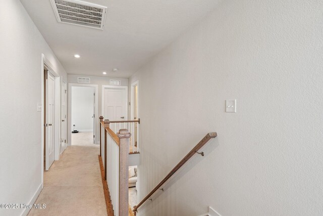 hall featuring visible vents, recessed lighting, light carpet, an upstairs landing, and baseboards