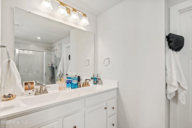 bathroom with double vanity, visible vents, a sink, and a stall shower