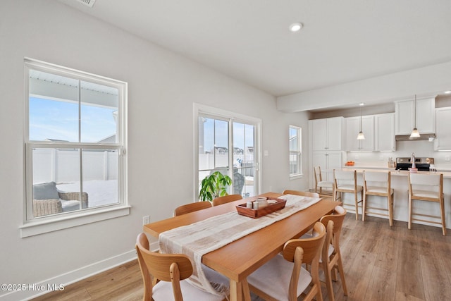 dining space with light wood finished floors, baseboards, and recessed lighting