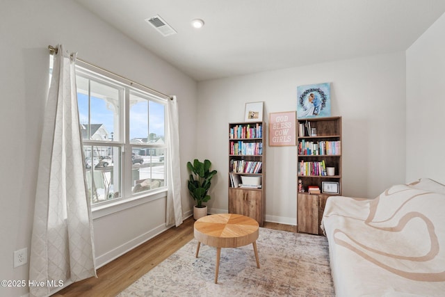 sitting room featuring visible vents, baseboards, and light wood-type flooring