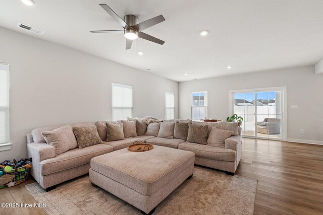 living room featuring visible vents, baseboards, a ceiling fan, recessed lighting, and wood finished floors