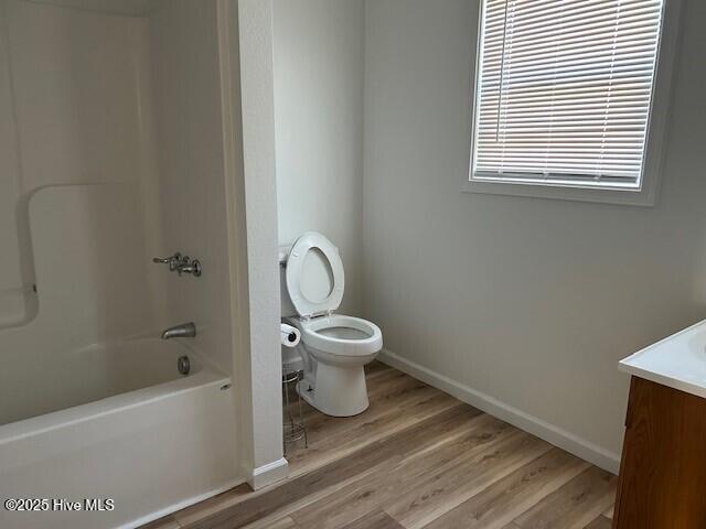 409 E Broad St, Elizabeth City, NC 27909 - full bath with shower / bathing tub combination, vanity, toilet, wood finished floors, and baseboards