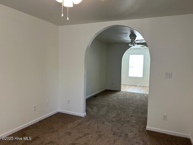 409 E Broad St, Elizabeth City, NC 27909 - carpeted empty room featuring arched walkways, ceiling fan, and baseboards