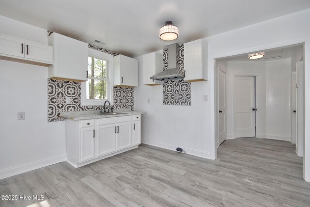 504 Belmont Ave SW, Wilson, NC 27893 - kitchen with wall chimney range hood, baseboards, light countertops, and a sink
