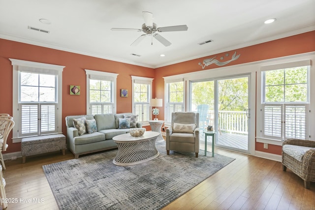 living area with a ceiling fan, visible vents, and a healthy amount of sunlight