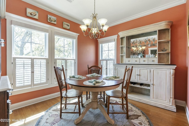 dining area featuring baseboards, a notable chandelier, light wood finished floors, and crown molding