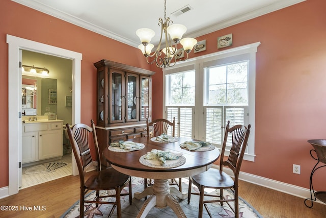 dining area with visible vents, baseboards, ornamental molding, wood finished floors, and a notable chandelier