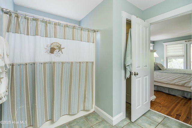 ensuite bathroom with baseboards, ensuite bath, and tile patterned flooring