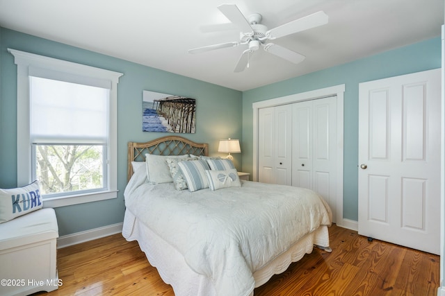 bedroom featuring wood finished floors, ceiling fan, baseboards, and a closet